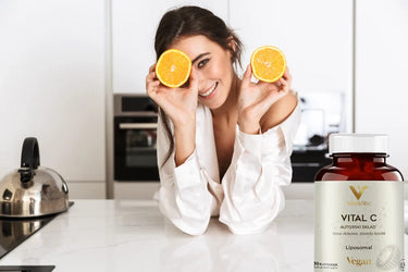 Kobieta przyjmująca witaminę C i butelka Vital C