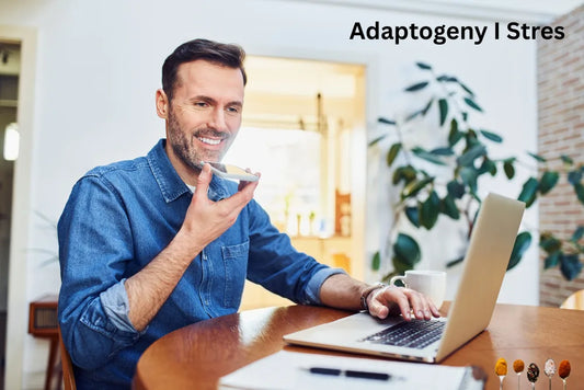 Mężczyzna siedzący przy stole, pracujący na laptopie i rozmawiający przez telefon