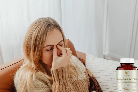 Kobieta z wzdęciami brzucha i butelką produktu Microbiome Support
